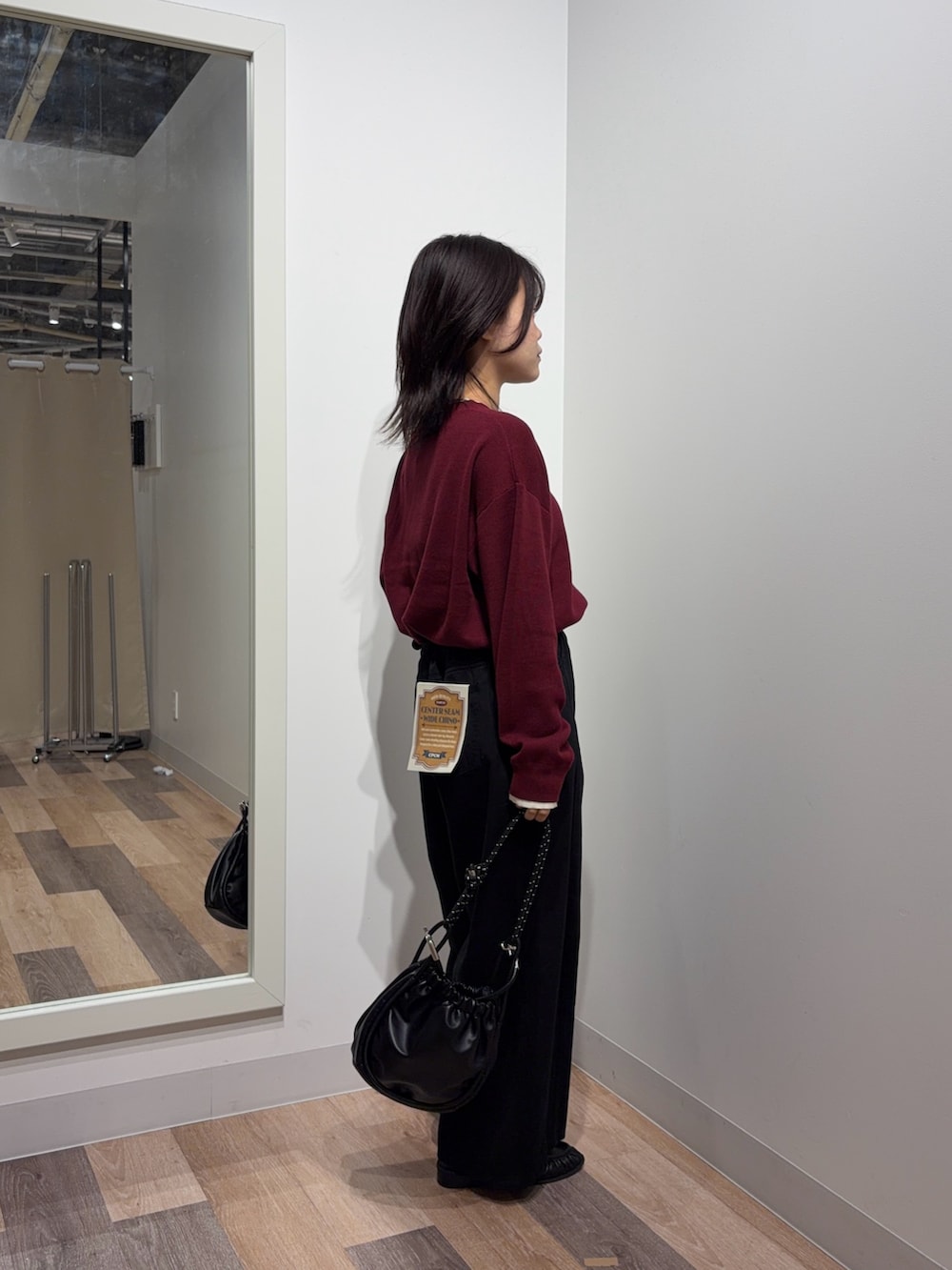 レッド系のニット/セーター、ブラック系のその他パンツ、ブラック系のショルダーバッグを着用したレディースの秋コーディネートの2枚目の写真