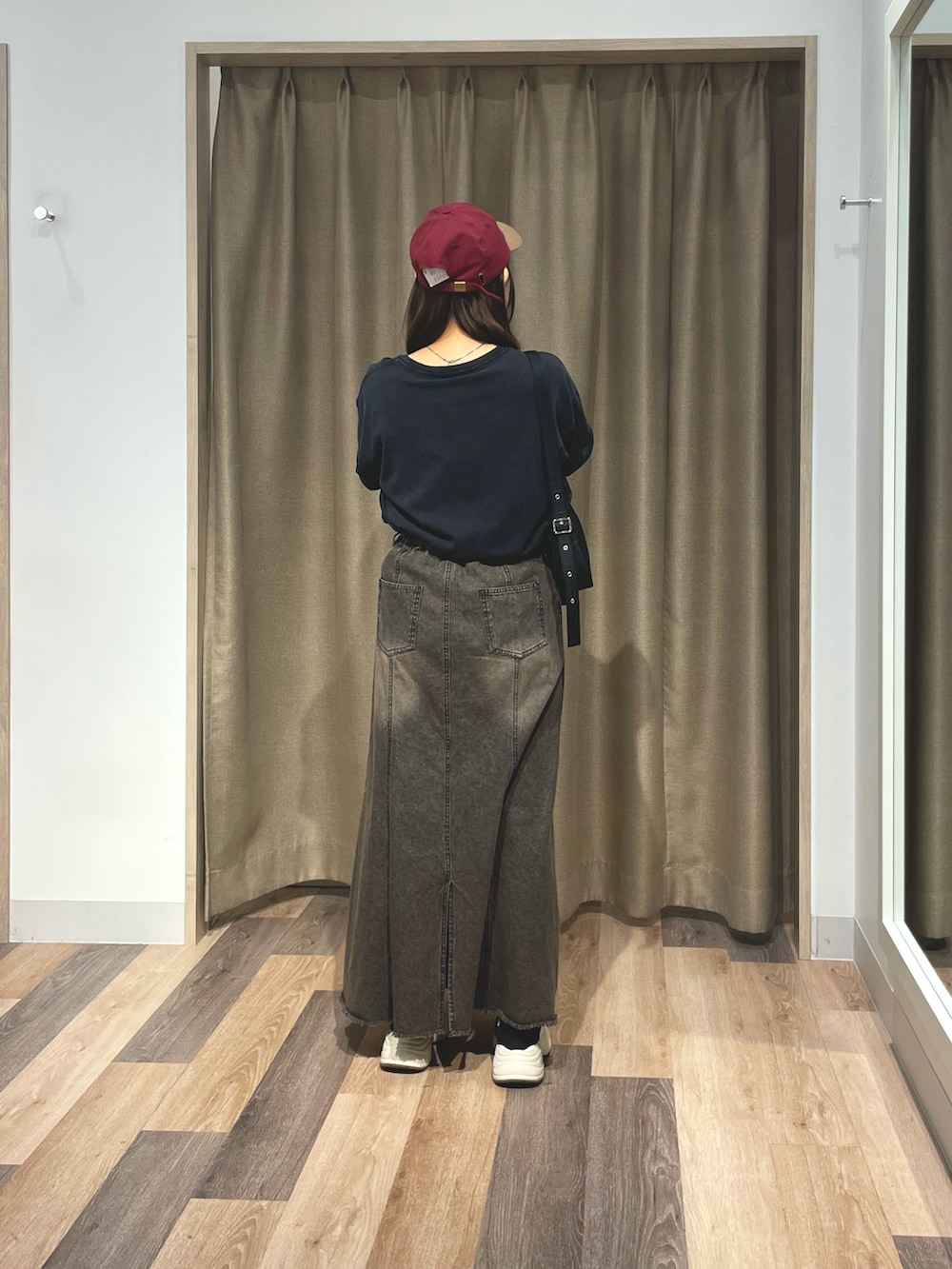 ホワイト系のTシャツ/カットソー、ブラック系のスカート、レッド系のキャップを着用したレディースの夏コーディネートの3枚目の写真