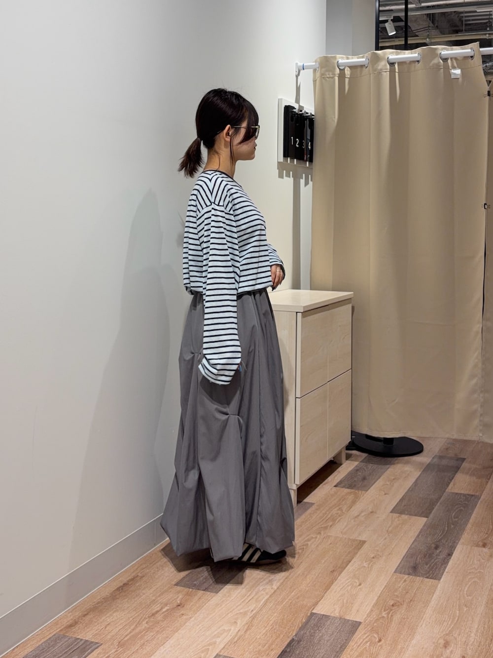 ブルー系のTシャツ/カットソー、グレー系のスカート、ブルー系のキャミソールを着用したレディースの春コーディネートの2枚目の写真