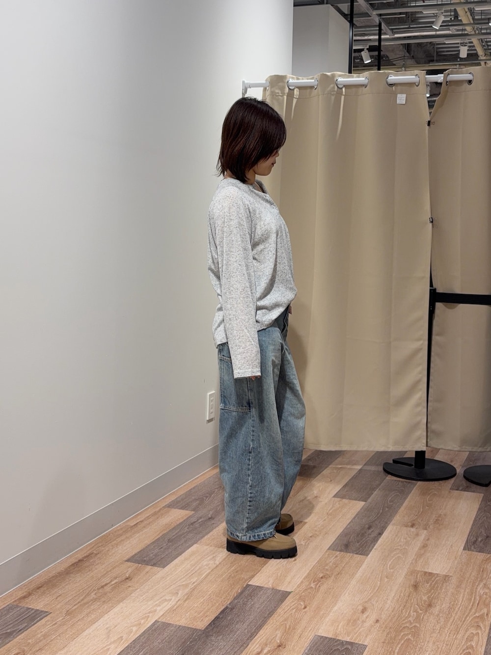 グレー系のニット/セーター、ブルー系のデニムパンツを着用したレディースの春コーディネートの2枚目の写真