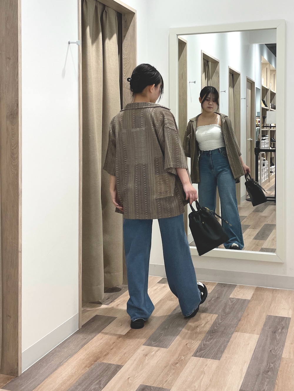 ブラウン系のシャツ/ブラウス、ブルー系のデニムパンツ、ブラック系のショルダーバッグを着用したレディースの春コーディネートの3枚目の写真