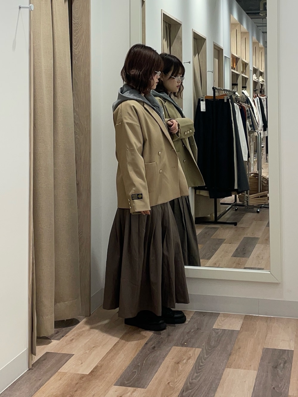 ベージュ系のテーラードジャケット、グレー系のニット/セーターを着用したレディースの冬コーディネートの2枚目の写真