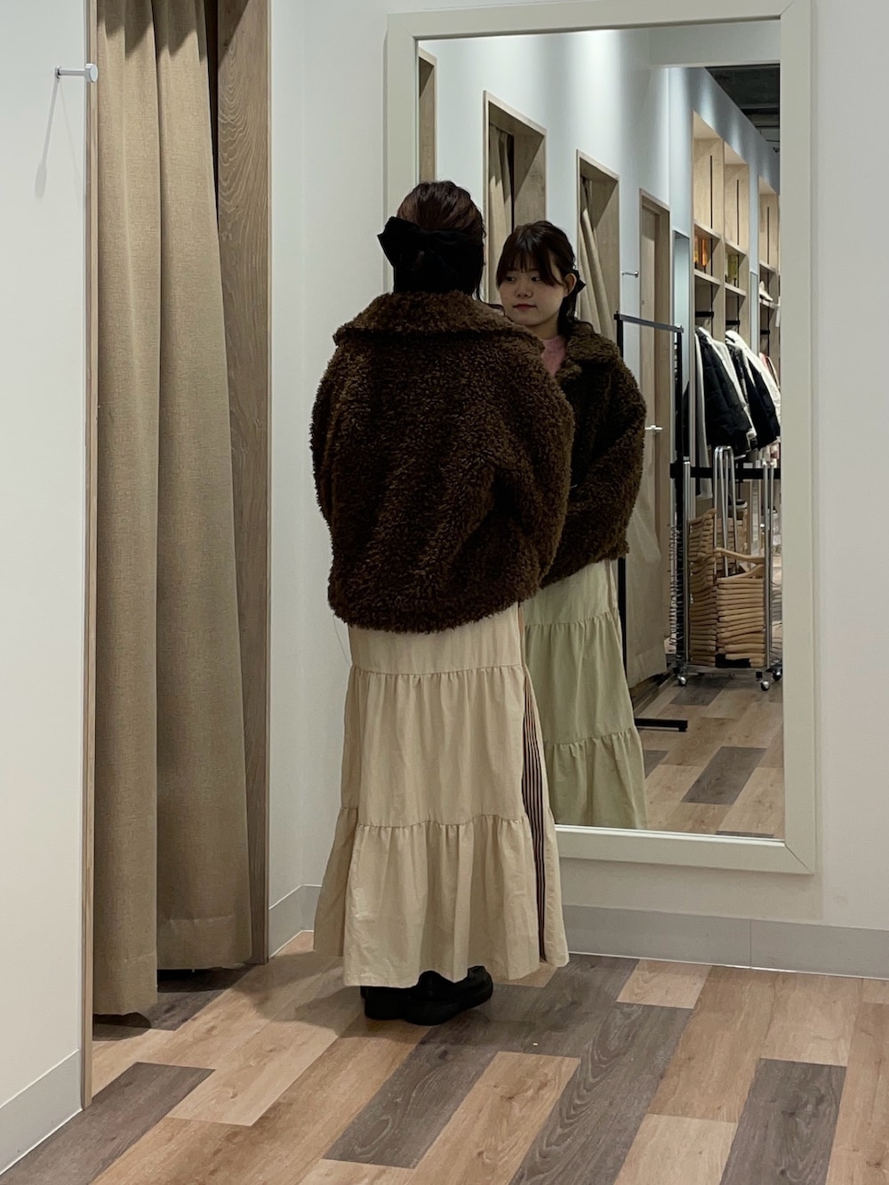 ブラウン系のブルゾン、ピンク系のニット/セーター、ホワイト系のスカートを着用したレディースの冬コーディネートの3枚目の写真