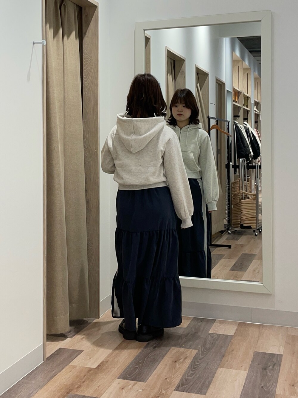 グレー系のパーカー、ブルー系のスカートを着用したレディースの冬コーディネートの3枚目の写真