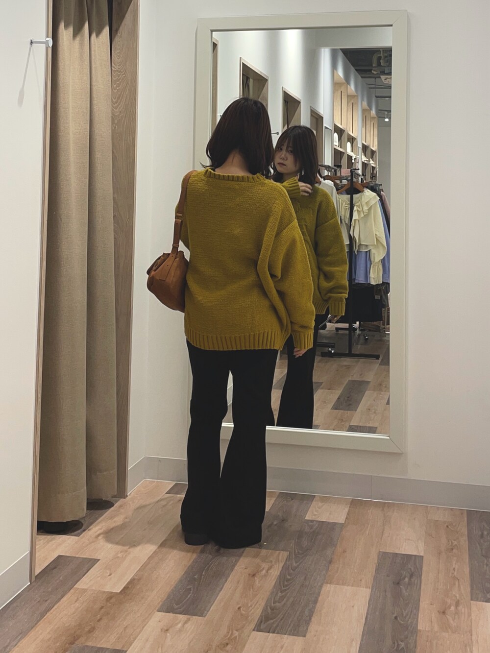 イエロー系のニット/セーター、ブラック系のその他パンツ、ブラック系のトートバッグを着用したレディースの秋コーディネートの3枚目の写真