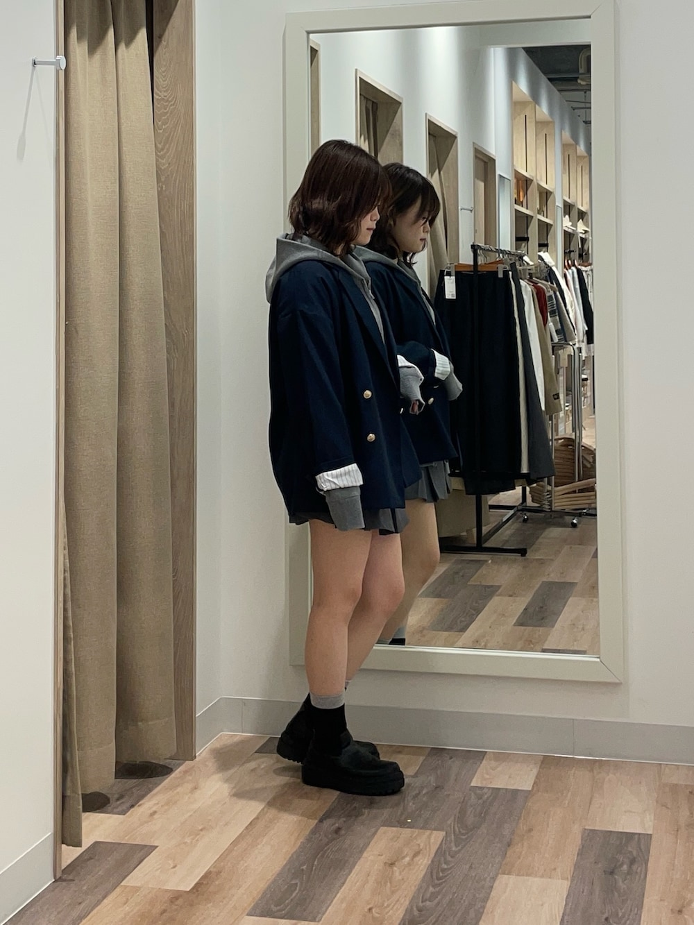 ベージュ系のテーラードジャケット、グレー系のニット/セーター、ブラック系のブーツを着用したレディースの冬コーディネートの2枚目の写真