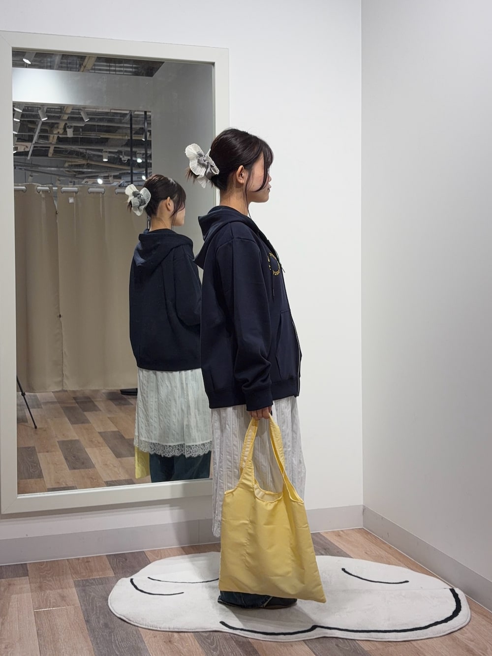 ブルー系のパーカー、ホワイト系のスカート、ブルー系のデニムパンツを着用したレディースの秋コーディネートの2枚目の写真