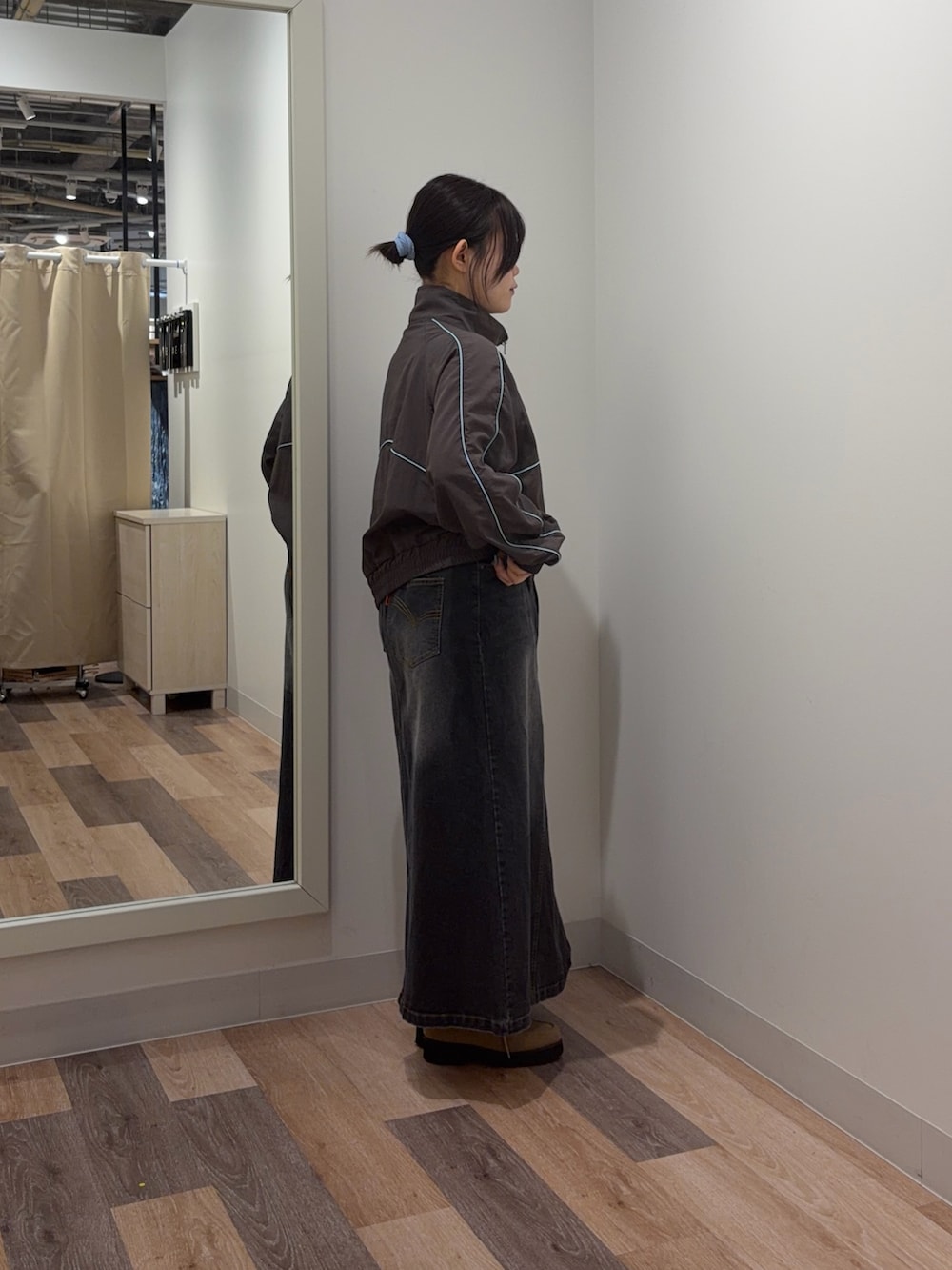 グレー系のブルゾン、ブラック系のスカートを着用したレディースの春コーディネートの2枚目の写真