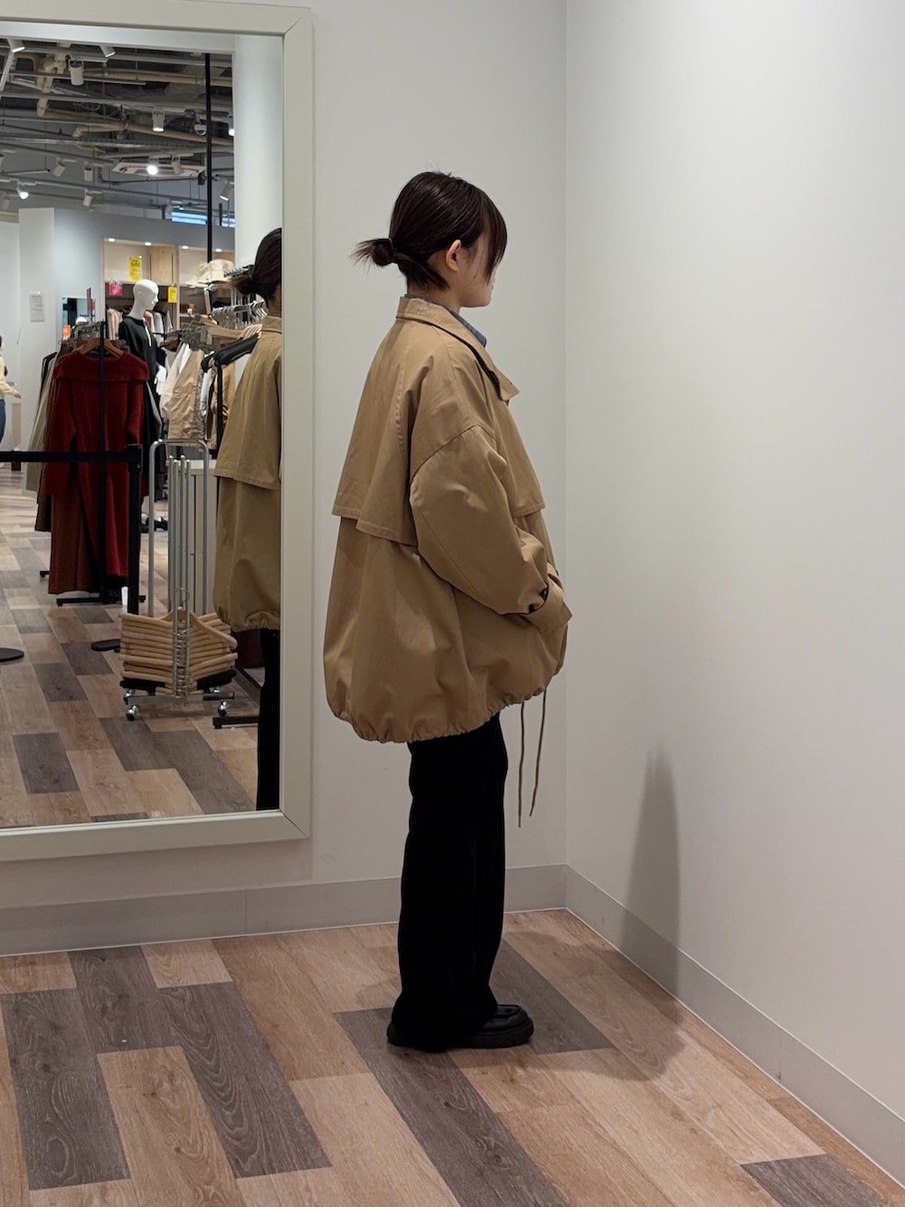 ベージュ系のトレンチコート、ブルー系のシャツ/ブラウス、ブラック系のその他パンツを着用したレディースの冬コーディネートの2枚目の写真