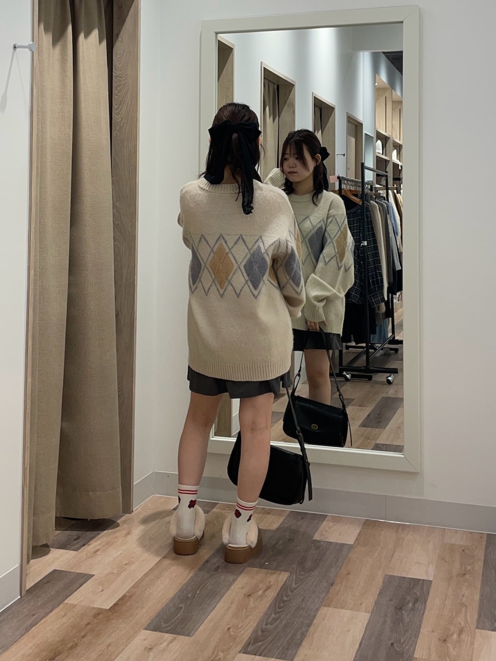 ホワイト系のニット/セーター、ブラック系のトートバッグ、イエロー系のブーツを着用したレディースの冬コーディネートの3枚目の写真