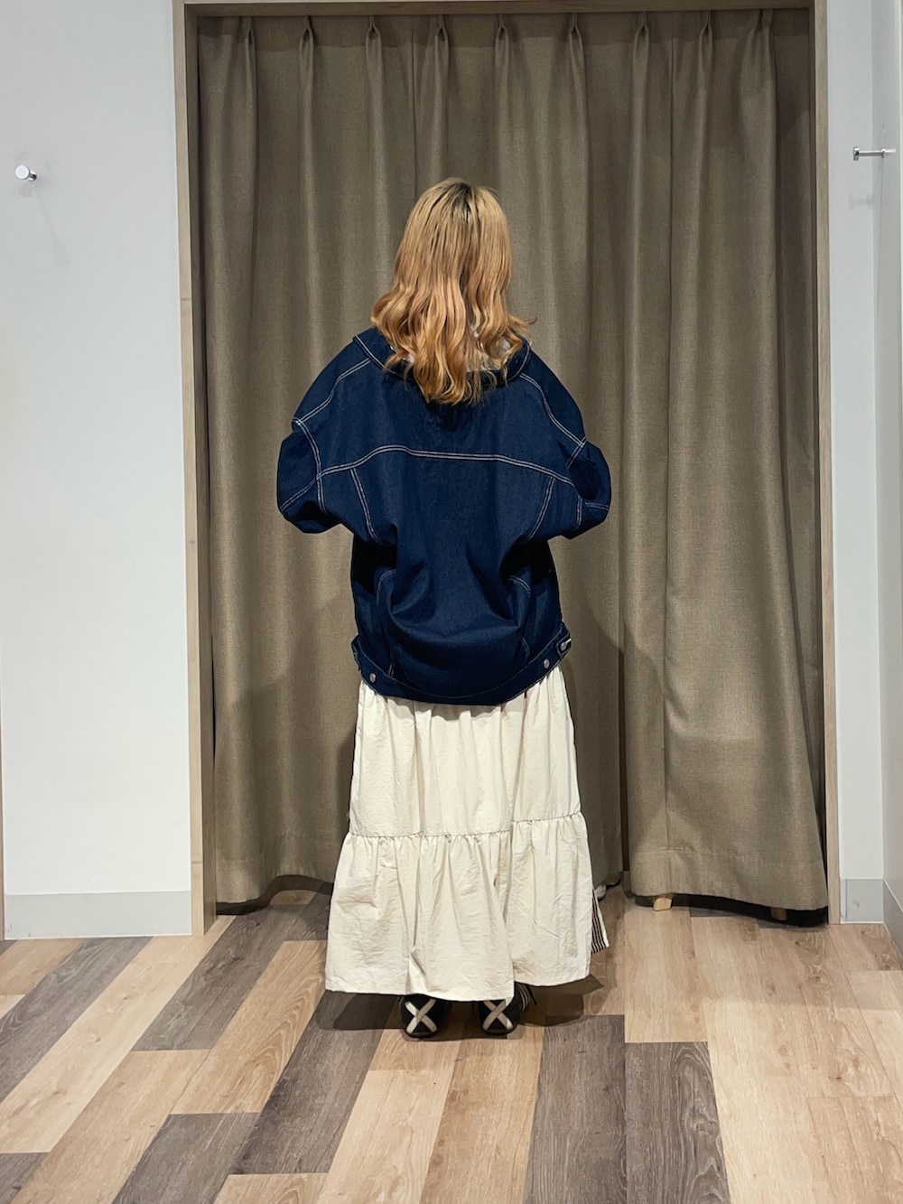 ホワイト系のスカート、グレー系のTシャツ/カットソー、ブラック系のデニムジャケットを着用したレディースの夏コーディネートの3枚目の写真