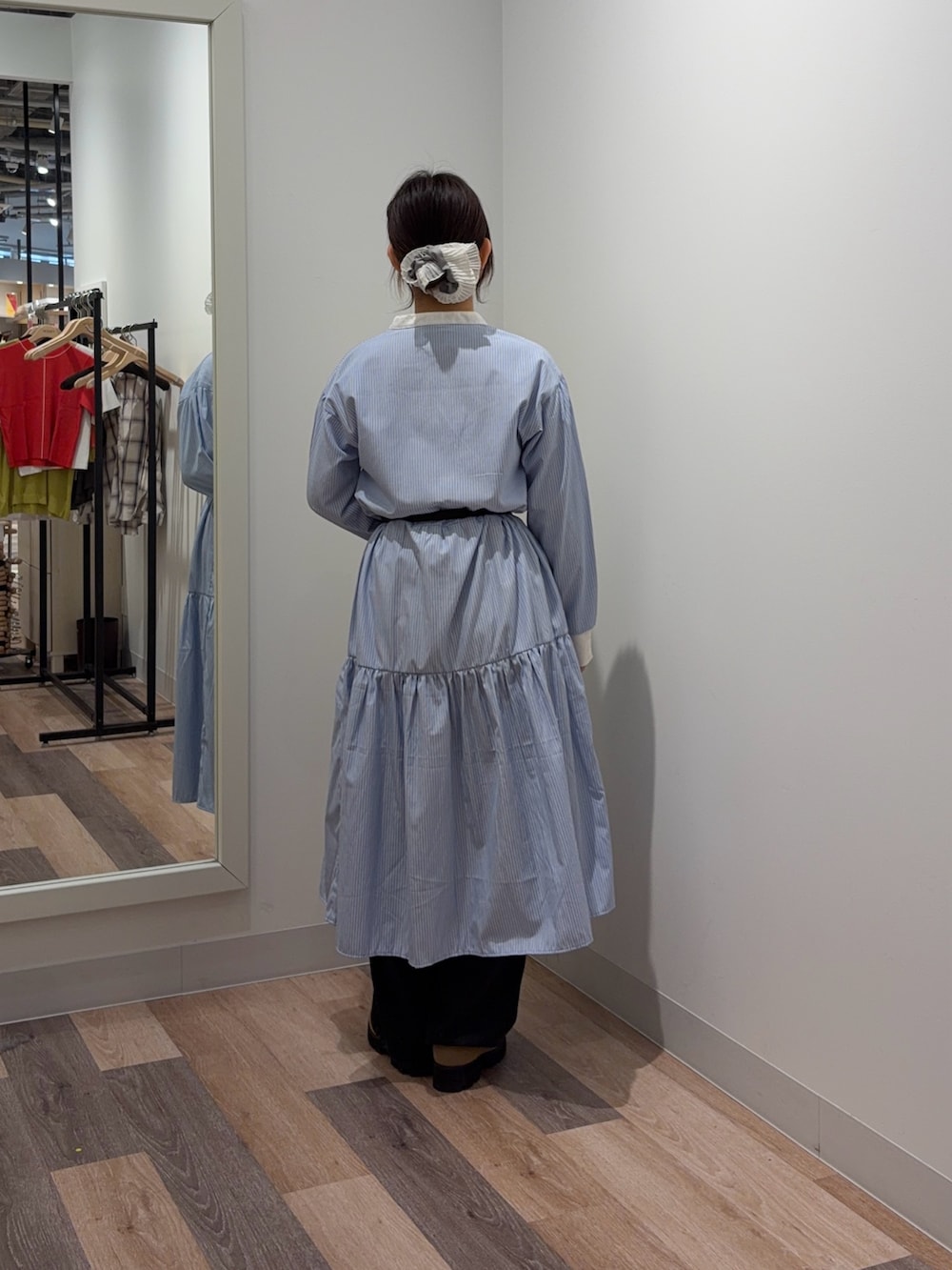 ブルー系のワンピース、ブラック系のデニムパンツを着用したレディースの春コーディネートの3枚目の写真