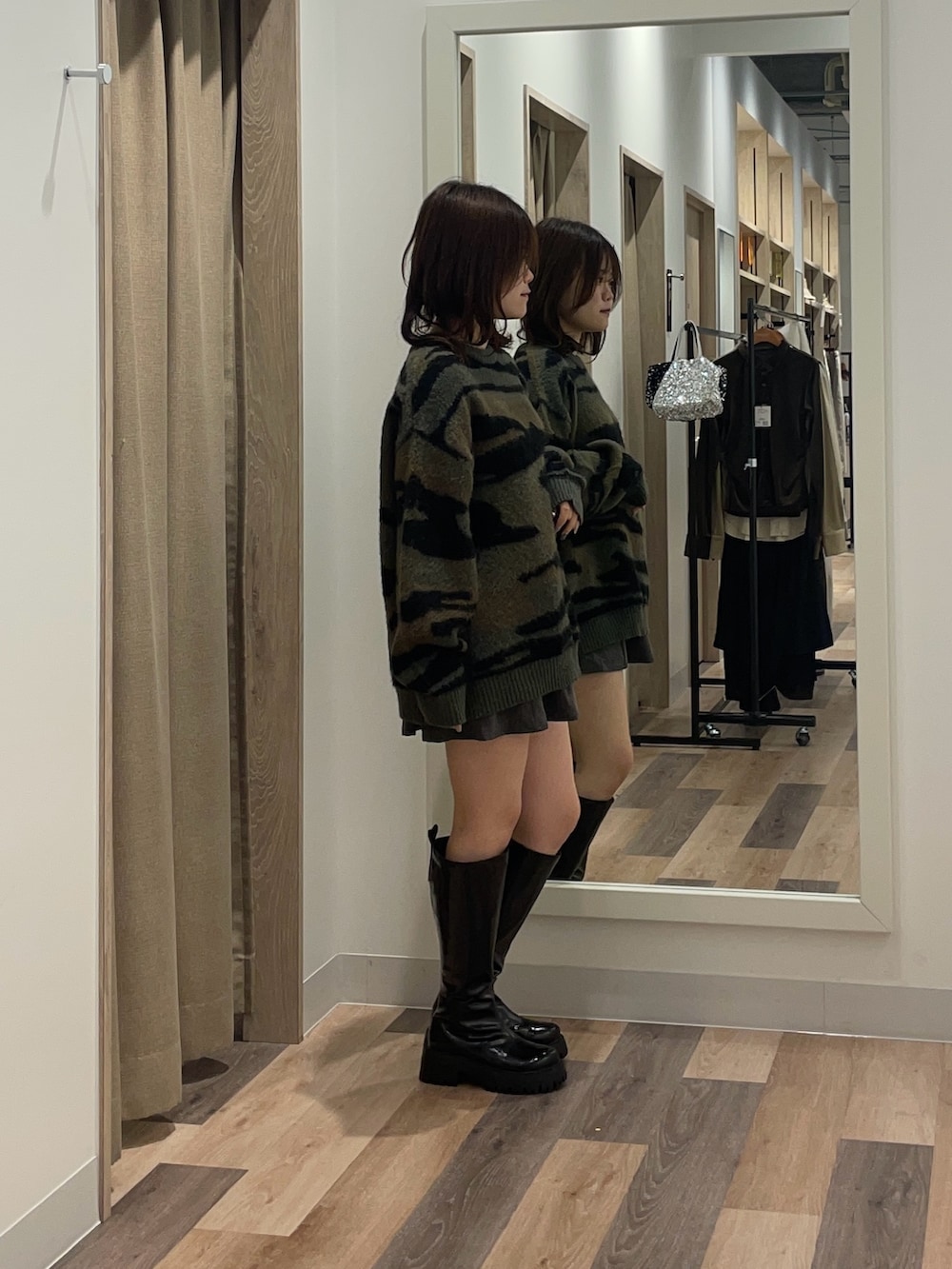 グリーン系のニット/セーターを着用したレディースの冬コーディネートの2枚目の写真