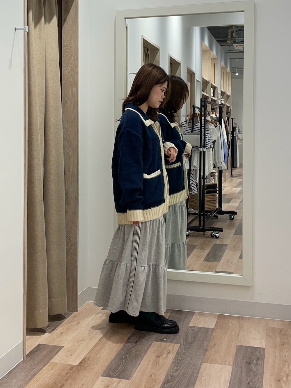 ブルー系のカーディガン/ボレロ、グレー系のスカートを着用したレディースの秋コーディネートの2枚目の写真