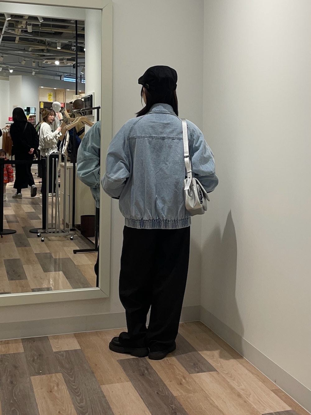 ブルー系のブルゾン、グレー系のスラックス、シルバー系のトートバッグを着用したレディースの冬コーディネートの3枚目の写真