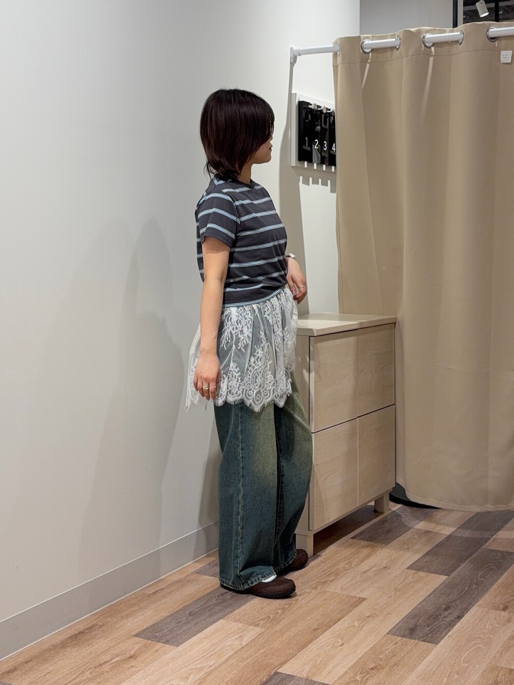 グレー系のTシャツ/カットソー、ホワイト系のキャミソール、ブルー系のデニムパンツを着用したレディースの春コーディネートの2枚目の写真