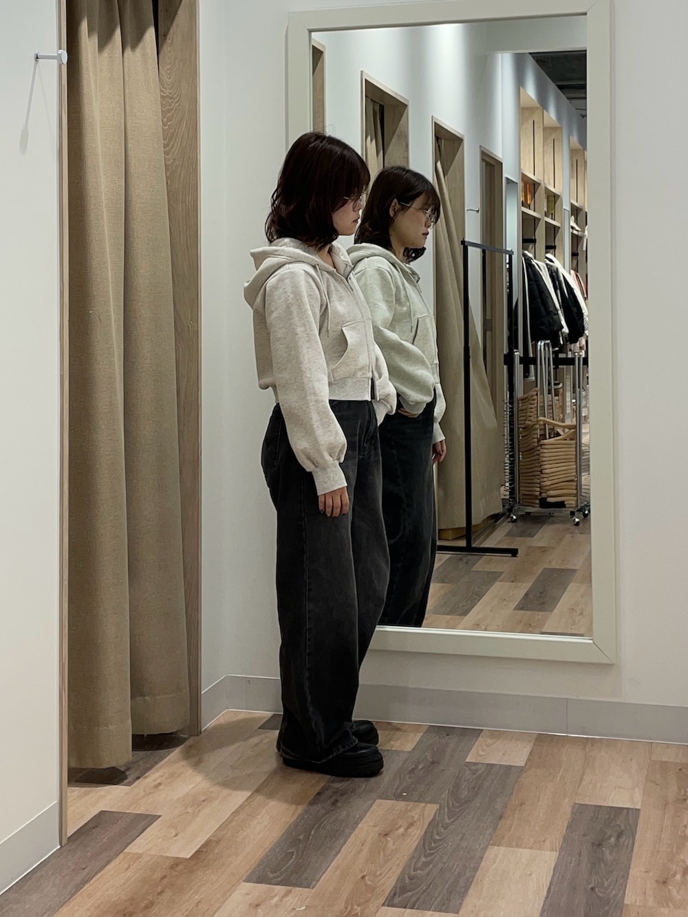 グレー系のパーカー、ブラック系のデニムパンツを着用したレディースの冬コーディネートの2枚目の写真