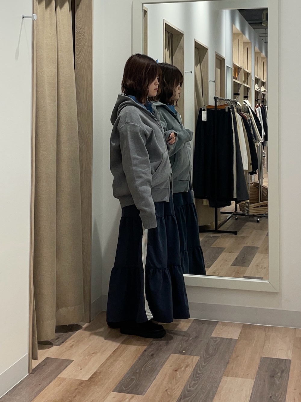 ブラック系のブルゾン、グレー系のニット/セーター、ブルー系のスカートを着用したレディースの冬コーディネートの3枚目の写真