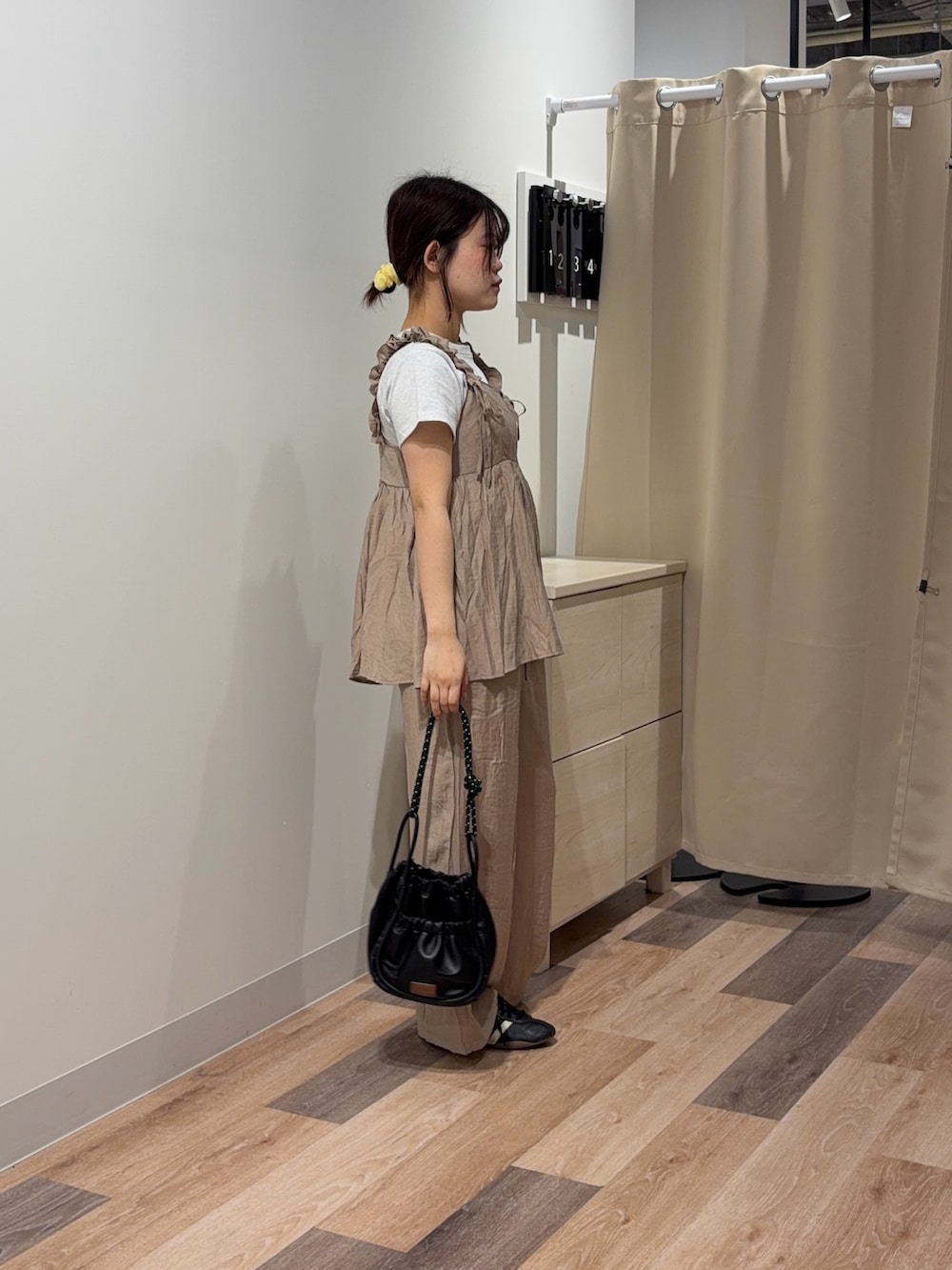 ベージュ系のワンピース、グレー系のTシャツ/カットソー、ブラック系のショルダーバッグを着用したレディースの春コーディネートの2枚目の写真