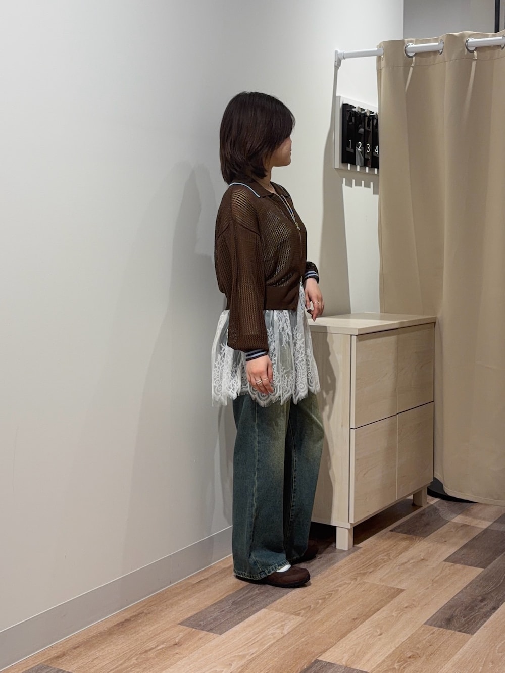 ブラウン系のカーディガン/ボレロ、ホワイト系のキャミソール、ブルー系のデニムパンツを着用したレディースの春コーディネートの2枚目の写真