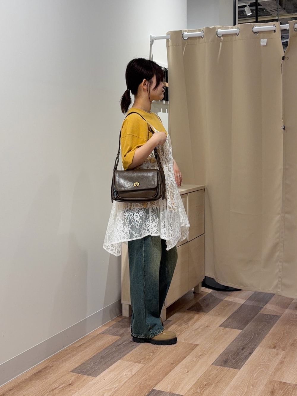 イエロー系のTシャツ/カットソー、ホワイト系のシャツ/ブラウス、ブルー系のデニムパンツを着用したレディースの春コーディネートの2枚目の写真