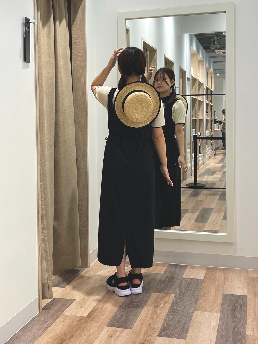 ブラック系のワンピース、ホワイト系のTシャツ/カットソー、ブラック系のサンダルを着用したレディースの夏コーディネートの3枚目の写真