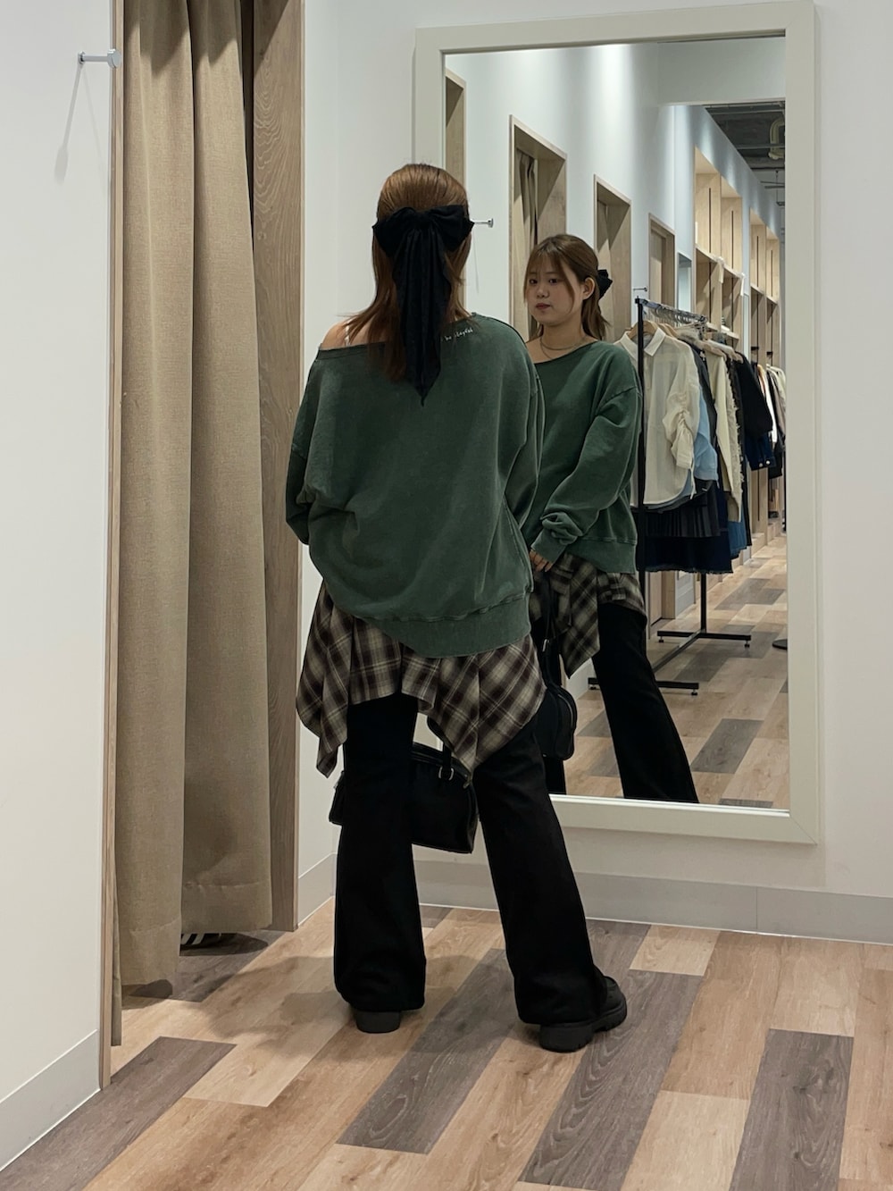 グリーン系のスウェット、グリーン系のスカート、ブラック系のその他パンツを着用したレディースの秋コーディネートの3枚目の写真