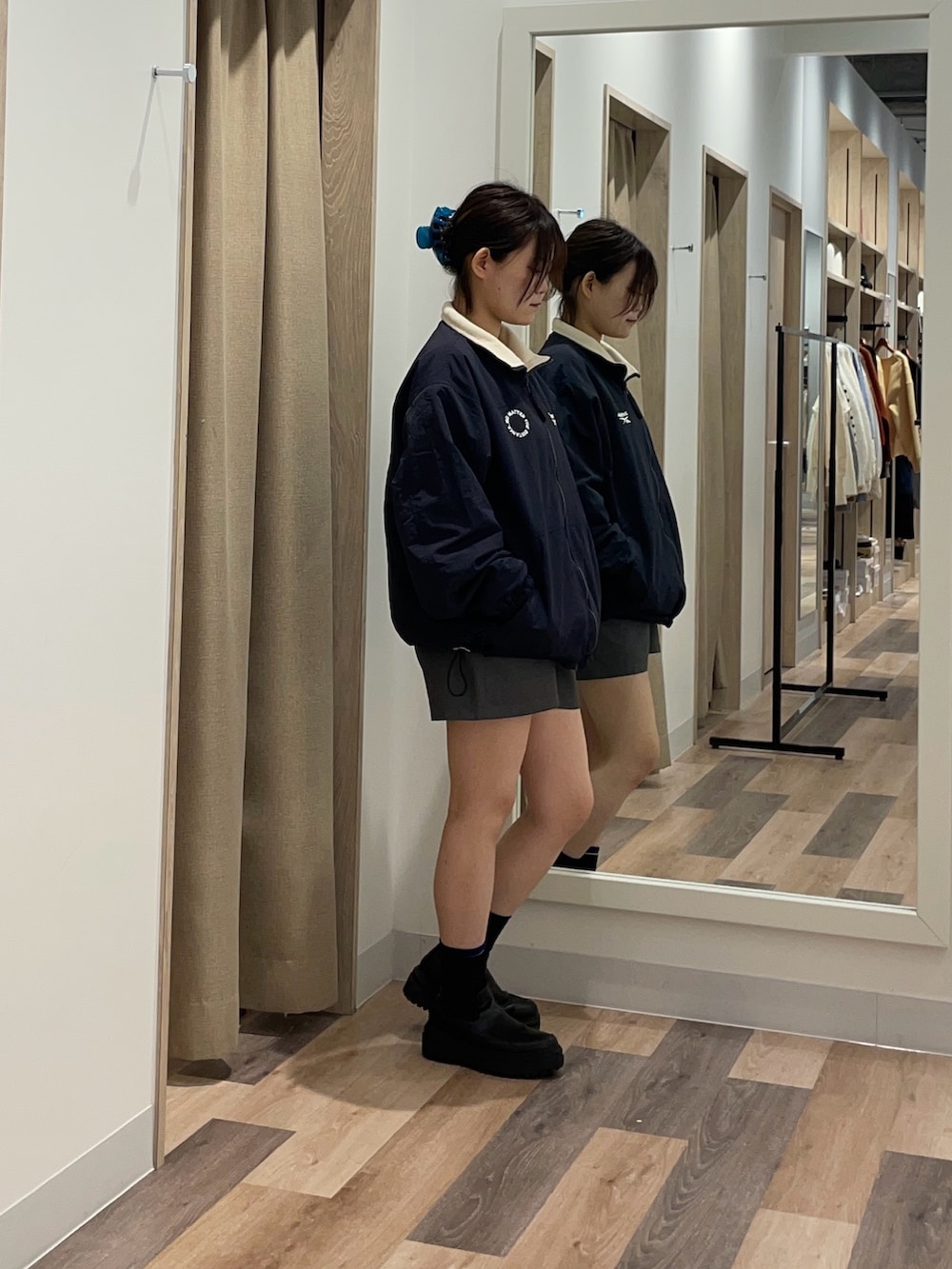 ブルー系のブルゾン、ブラック系のブーツを着用したレディースの秋コーディネートの2枚目の写真