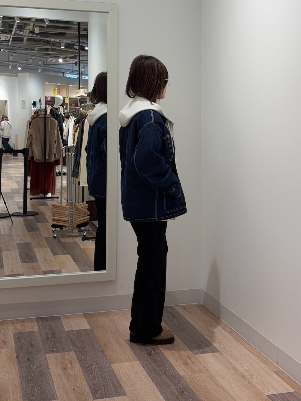 ブルー系のデニムジャケット、ホワイト系のパーカー、ブラック系のその他パンツを着用したレディースの冬コーディネートの2枚目の写真