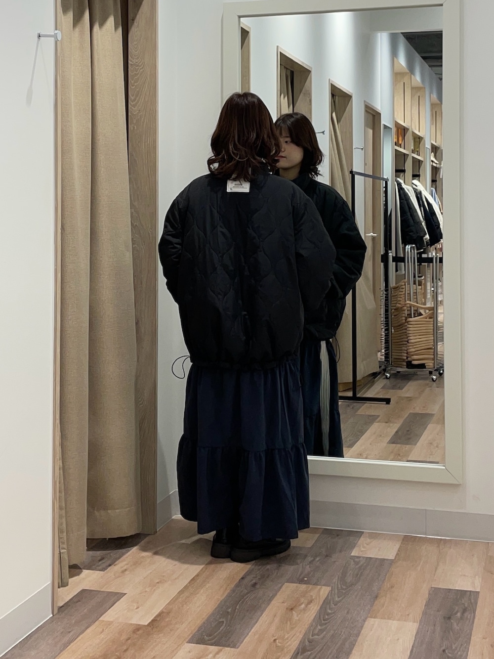 ブラック系のブルゾン、ブルー系のスカートを着用したレディースの冬コーディネートの3枚目の写真