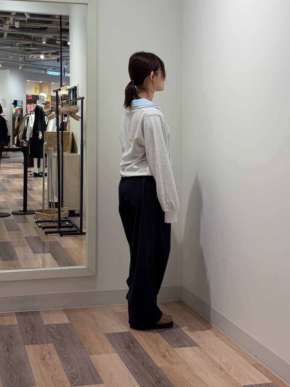 グレー系のTシャツ/カットソー、ブラック系のスラックスを着用したレディースの冬コーディネートの2枚目の写真