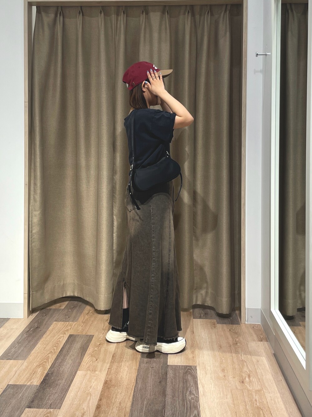 ホワイト系のTシャツ/カットソー、ブラック系のスカート、レッド系のキャップを着用したレディースの夏コーディネートの2枚目の写真