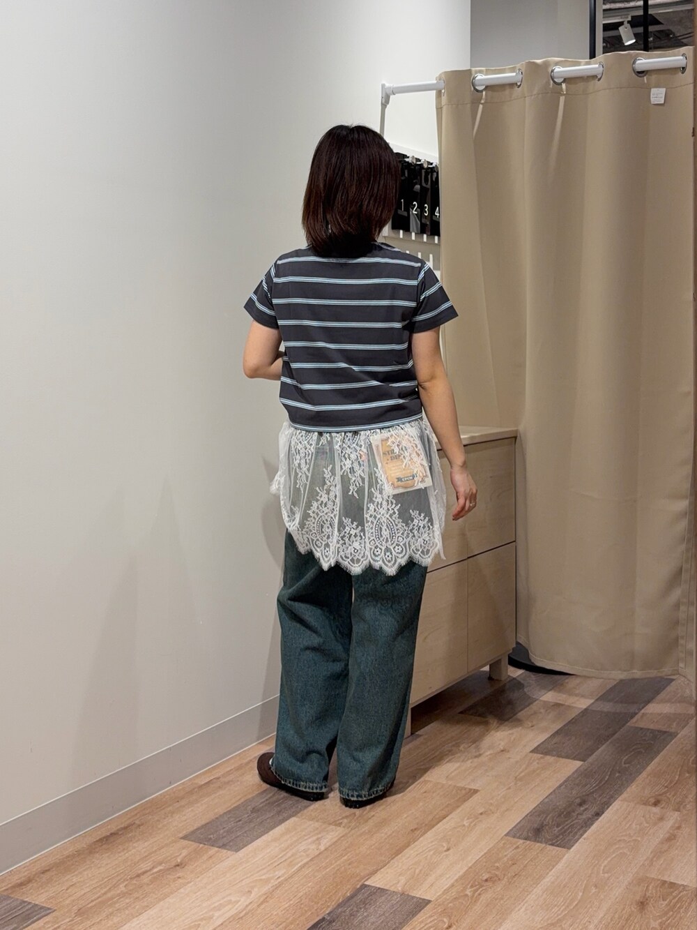 グレー系のTシャツ/カットソー、ホワイト系のキャミソール、ブルー系のデニムパンツを着用したレディースの春コーディネートの3枚目の写真