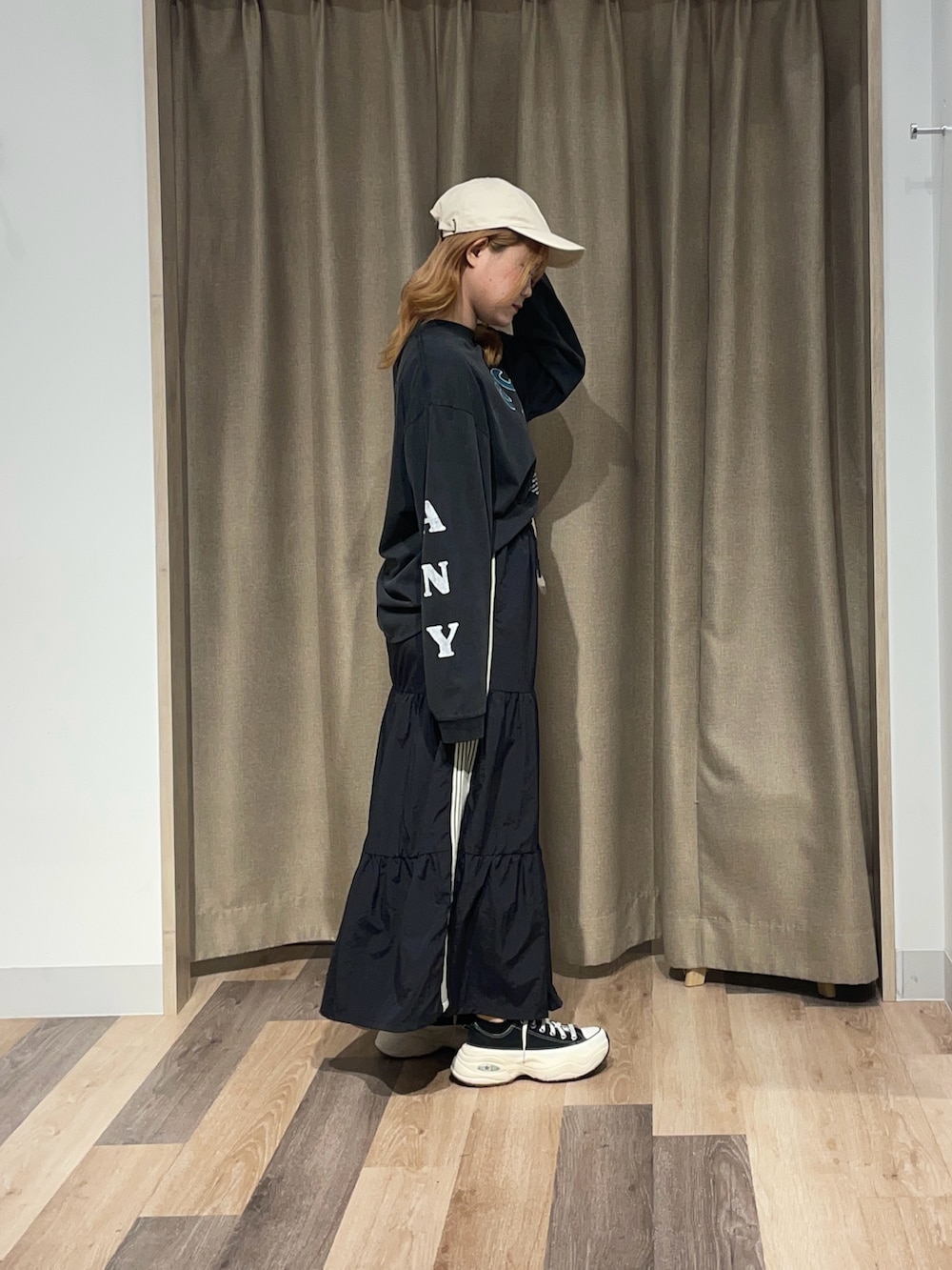 ホワイト系のスカート、ブラック系のTシャツ/カットソーを着用したレディースの夏コーディネートの2枚目の写真