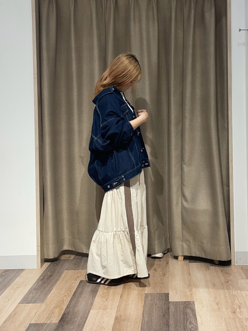 ホワイト系のスカート、グレー系のTシャツ/カットソー、ブラック系のデニムジャケットを着用したレディースの夏コーディネートの2枚目の写真