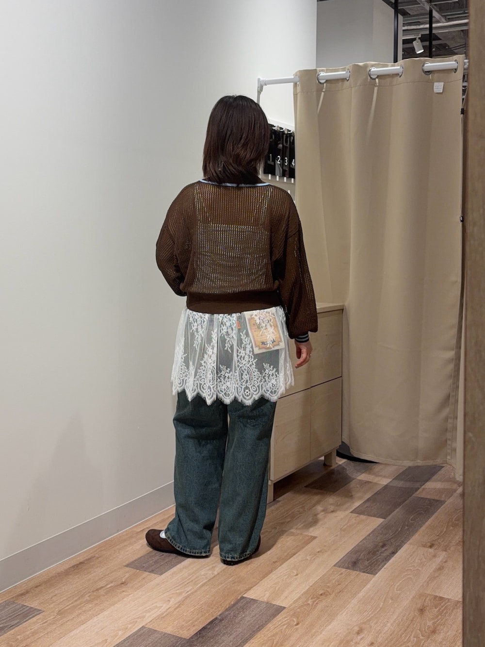 ブラウン系のカーディガン/ボレロ、ホワイト系のキャミソール、ブルー系のデニムパンツを着用したレディースの春コーディネートの3枚目の写真