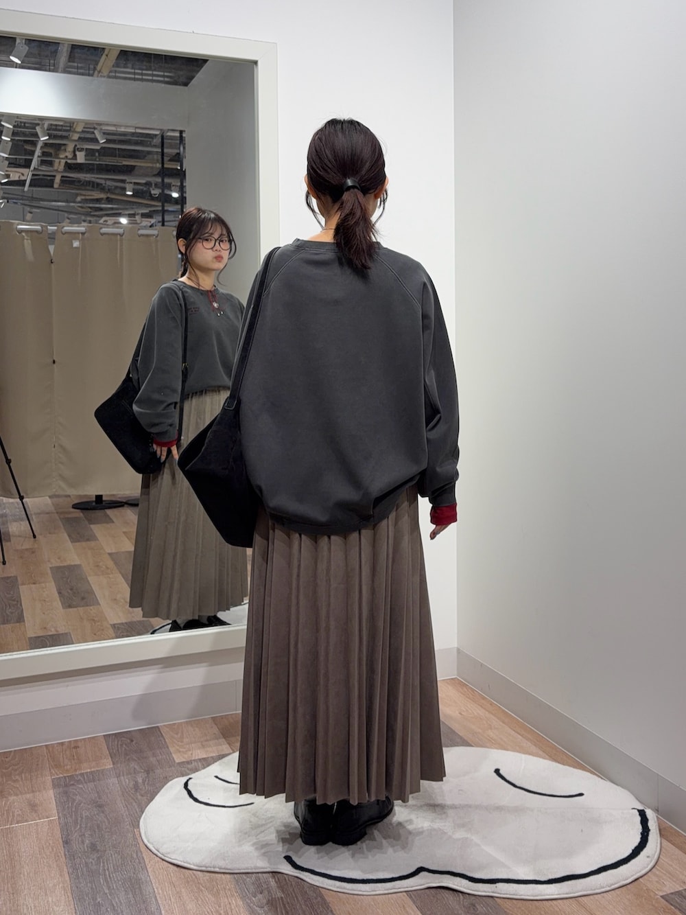レッド系のTシャツ/カットソー、グレー系のスカート、ブラック系のショルダーバッグを着用したレディースの秋コーディネートの3枚目の写真