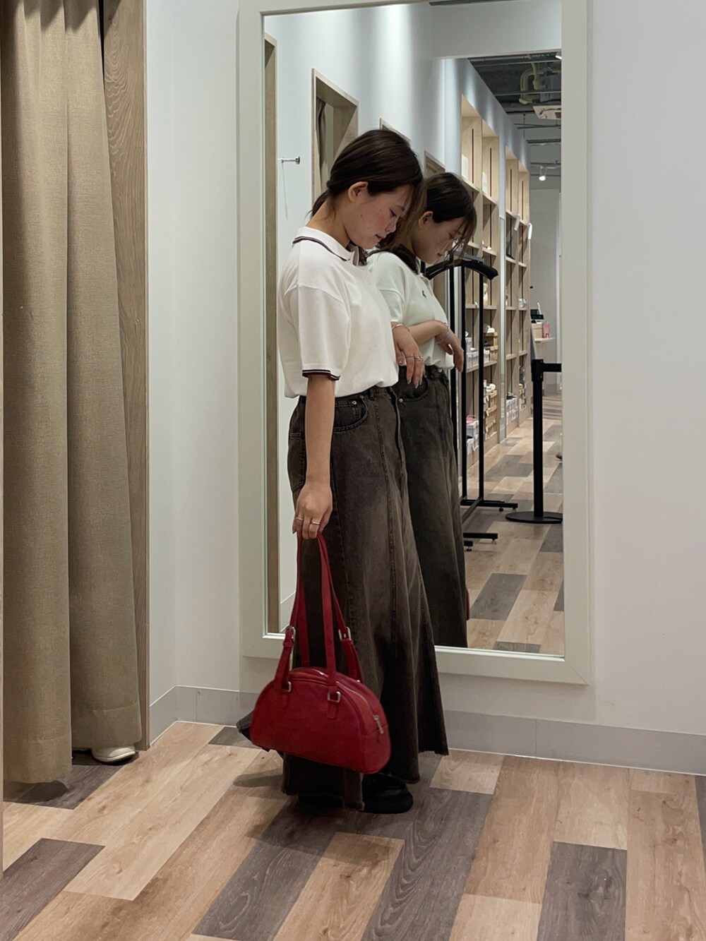 ブルー系のニット/セーター、ブルー系のスカート、ブラウン系のボストンバッグを着用したレディースの秋コーディネートの2枚目の写真