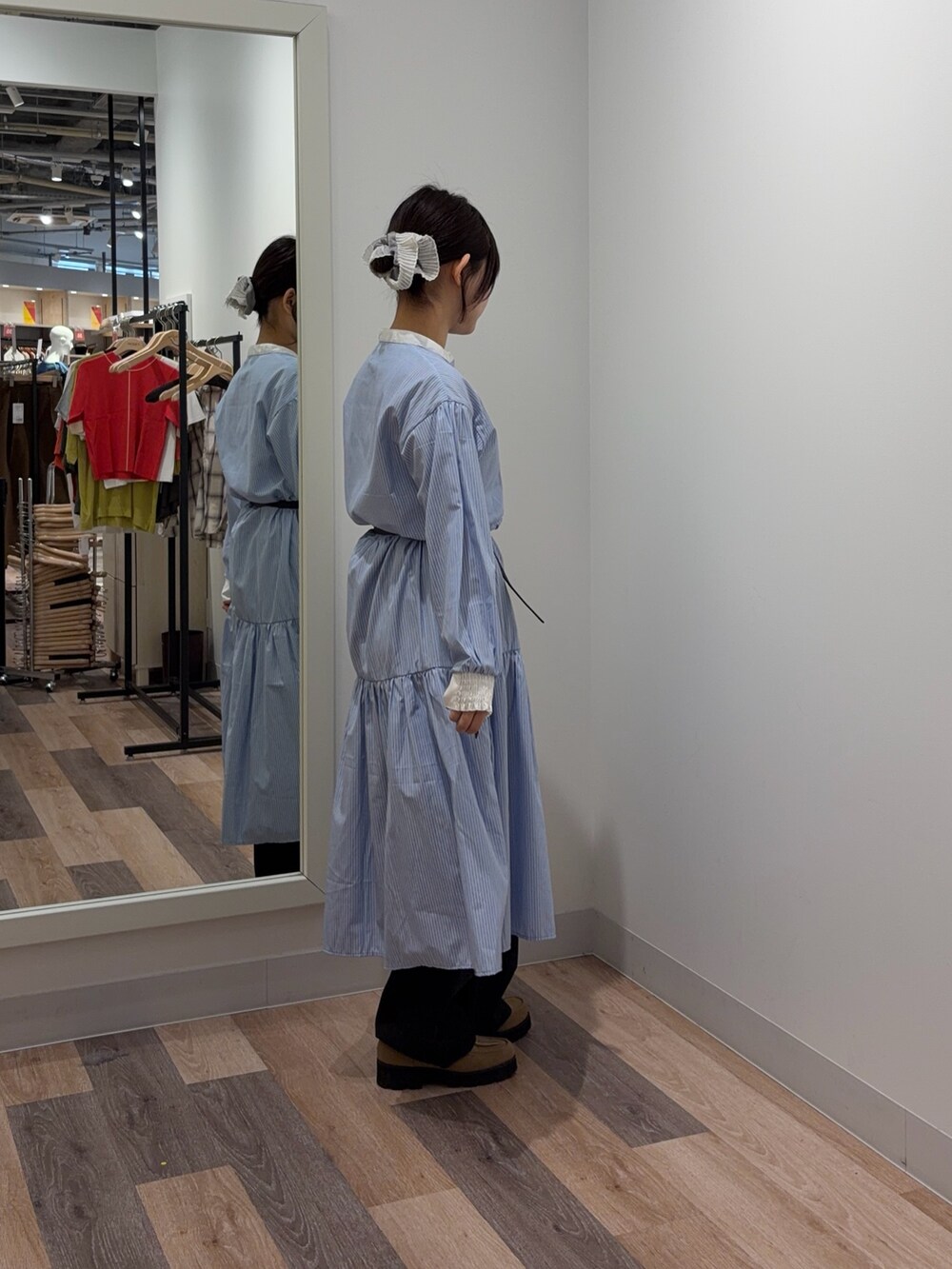 ブルー系のワンピース、ブラック系のデニムパンツを着用したレディースの春コーディネートの2枚目の写真