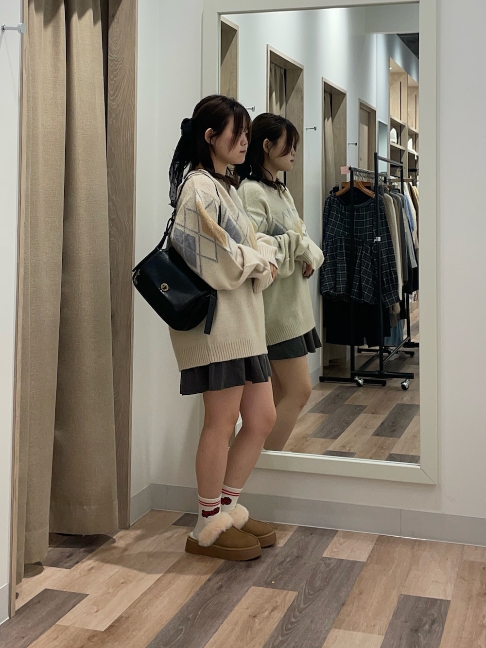 ホワイト系のニット/セーター、ブラック系のトートバッグ、イエロー系のブーツを着用したレディースの冬コーディネートの2枚目の写真