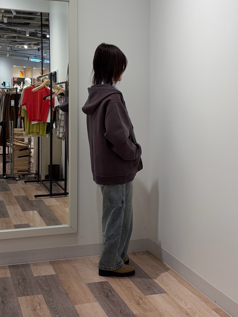 ブラウン系のパーカー、ブルー系のシャツ/ブラウス、ブルー系のデニムパンツを着用したレディースの春コーディネートの2枚目の写真