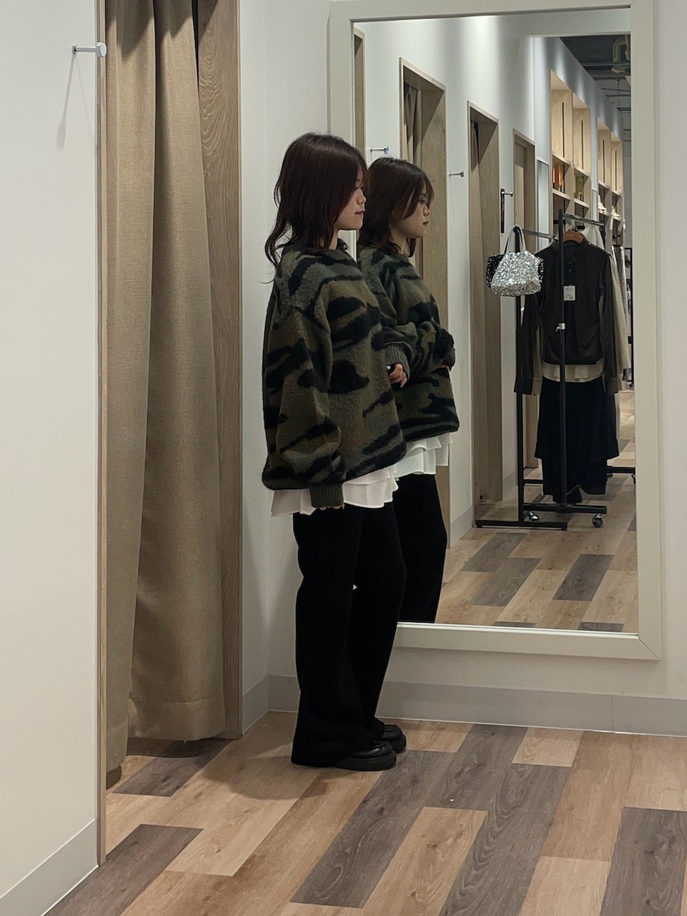 グリーン系のニット/セーター、ホワイト系のTシャツ/カットソー、ブラック系のその他パンツを着用したレディースの冬コーディネートの2枚目の写真