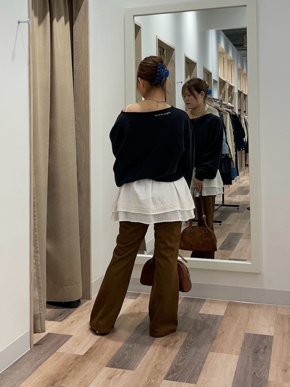 グリーン系のスウェット、ブラック系のその他パンツ、ブラウン系のボストンバッグを着用したレディースの秋コーディネートの3枚目の写真