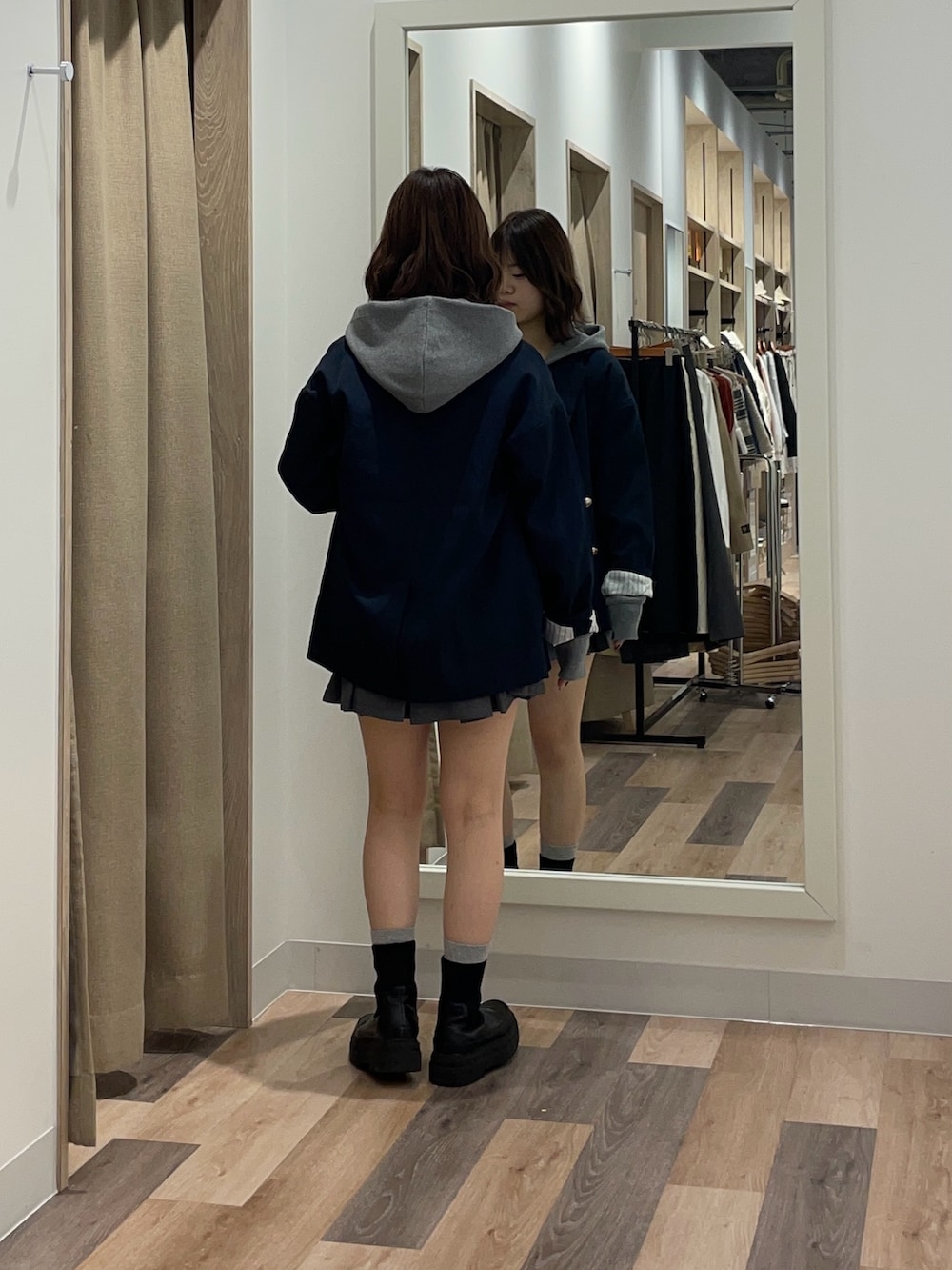 ベージュ系のテーラードジャケット、グレー系のニット/セーター、ブラック系のブーツを着用したレディースの冬コーディネートの3枚目の写真