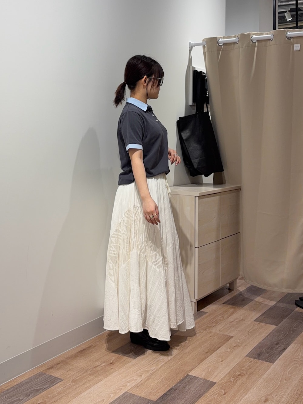グレー系のポロシャツ、ホワイト系のワンピースを着用したレディースの春コーディネートの2枚目の写真