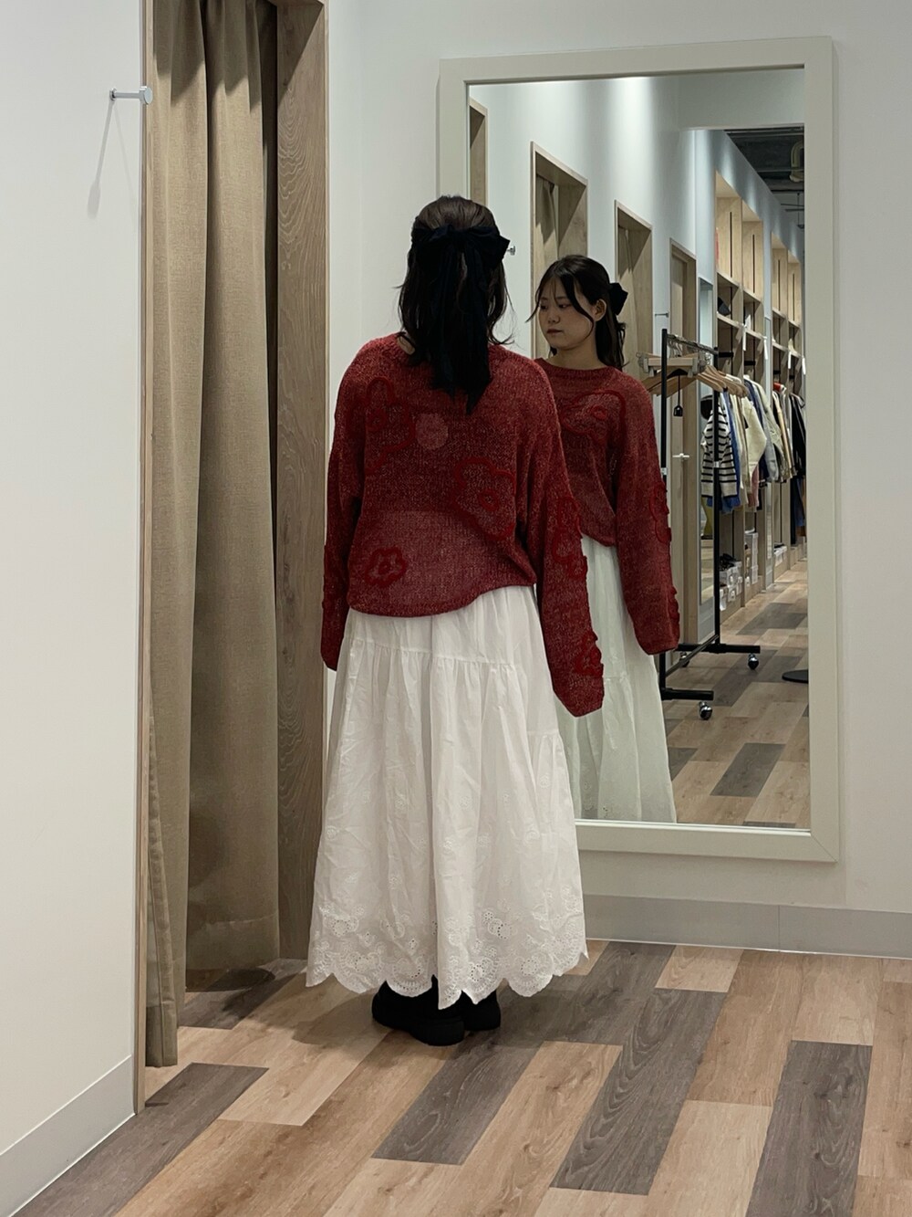 レッド系のニット/セーターを着用したレディースの秋コーディネートの3枚目の写真