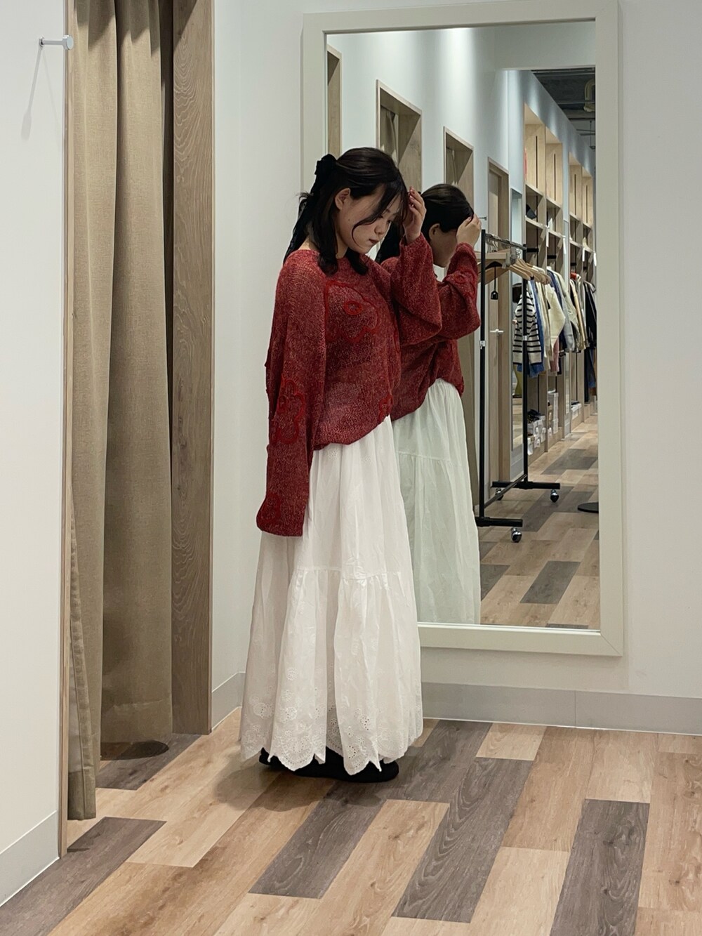 レッド系のニット/セーターを着用したレディースの秋コーディネートの2枚目の写真