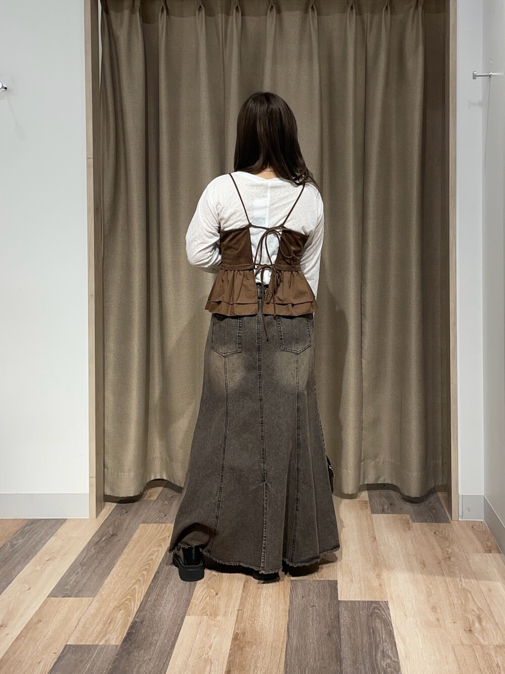 ホワイト系のTシャツ/カットソー、ブルー系のスカート、ブラウン系のボストンバッグを着用したレディースの秋コーディネートの3枚目の写真