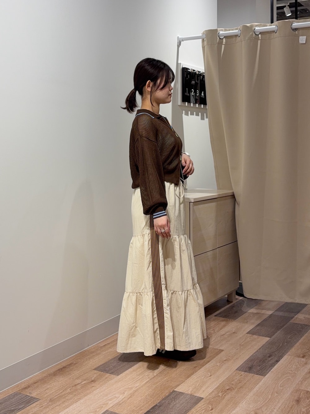 ホワイト系のスカート、ブラウン系のカーディガン/ボレロ、ホワイト系のキャミソールを着用したレディースの春コーディネートの2枚目の写真