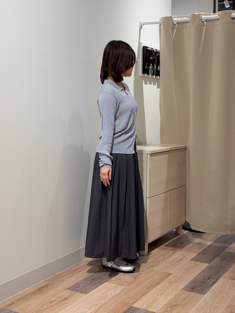 ホワイト系のキャミソール、グレー系のカーディガン/ボレロ、ベージュ系のスカートを着用したレディースの春コーディネートの2枚目の写真